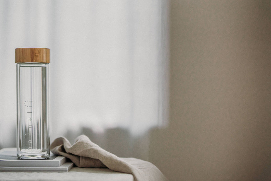 Reusable Glass Drinking Vessel Sitting On Books Near A Window